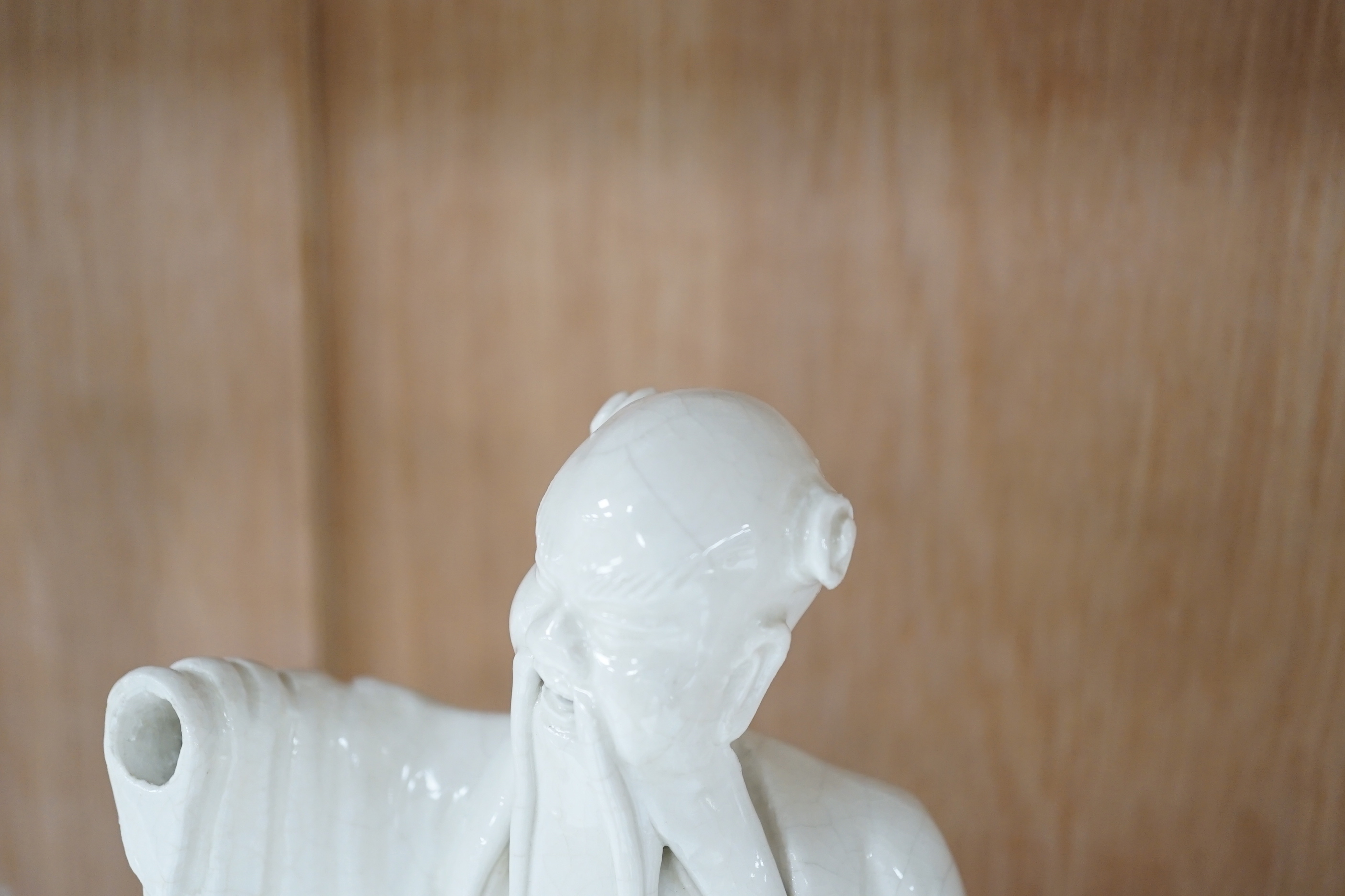 Seven Chinese blanc de Chine figures of immortals, each raised on carved hardwood bases, the largest 24cm high